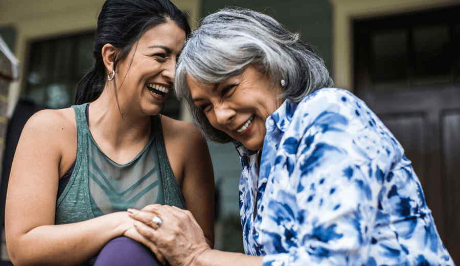 adult-women-embracing-laughing-on-porch